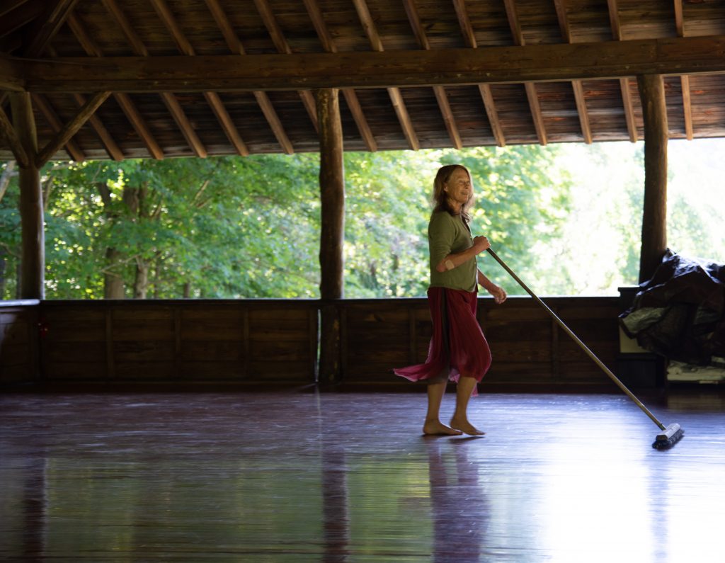 Woman sweeping dance floor.